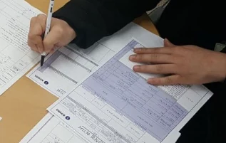 현장에서 종이 점검표에 볼펜으로 기록하는 모습